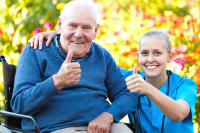 portrait of senior man and nurse giving thumbs up