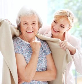 caregiver covering senior woman using towel