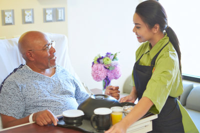 portrait of nurse giving food to senior man