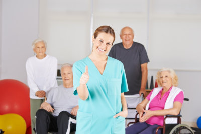 caregiver giving thumbs up while seniors at the back