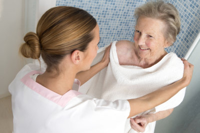 caregiver helping senior woman in bathing